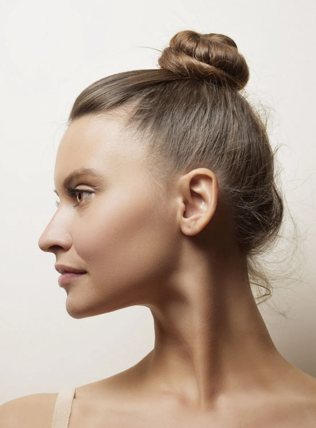Side profile of a woman with her hair up, showing a defined jawline